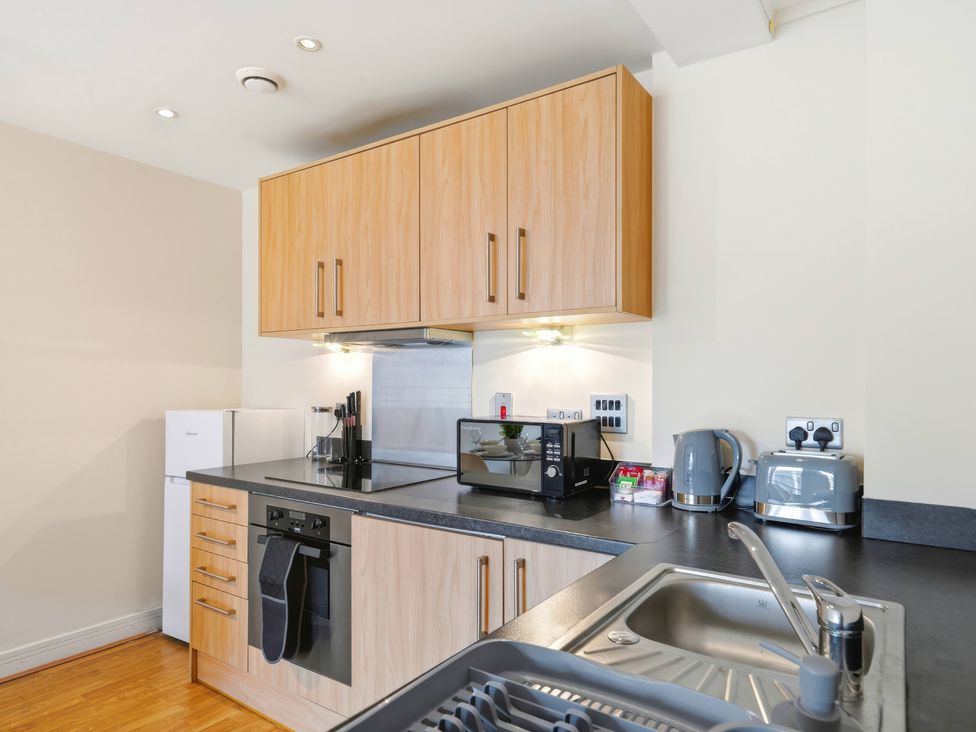 A kitchen with cabinets, sink, microwave, and appliances at Apartment 28 in Birmingham