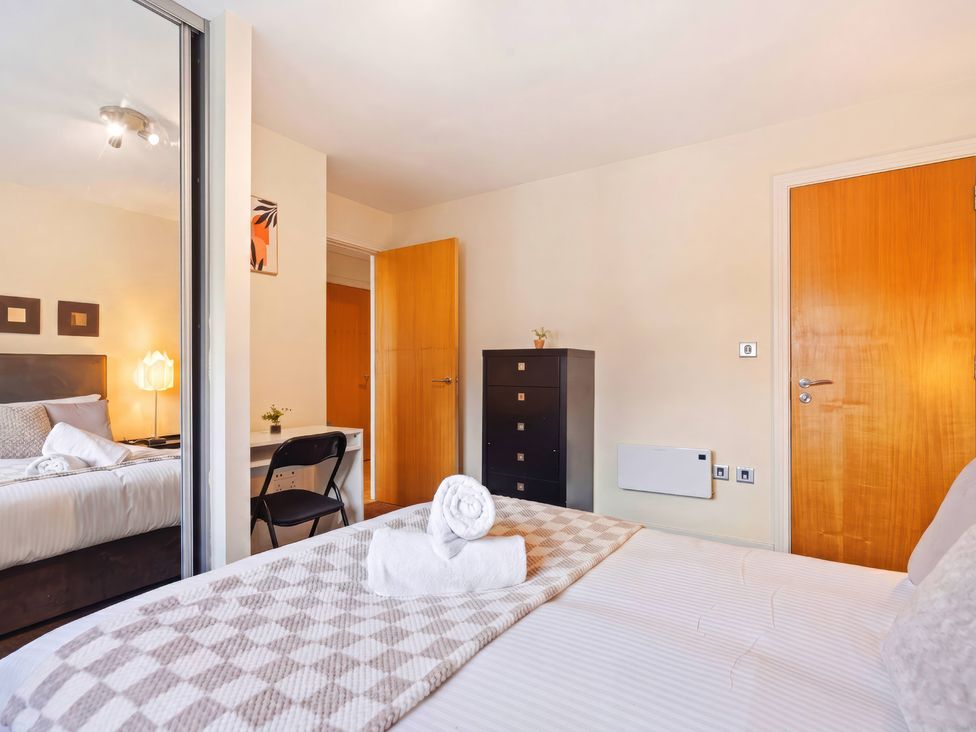 A bedroom with a bed and a chair at Apartment 28 in Birmingham