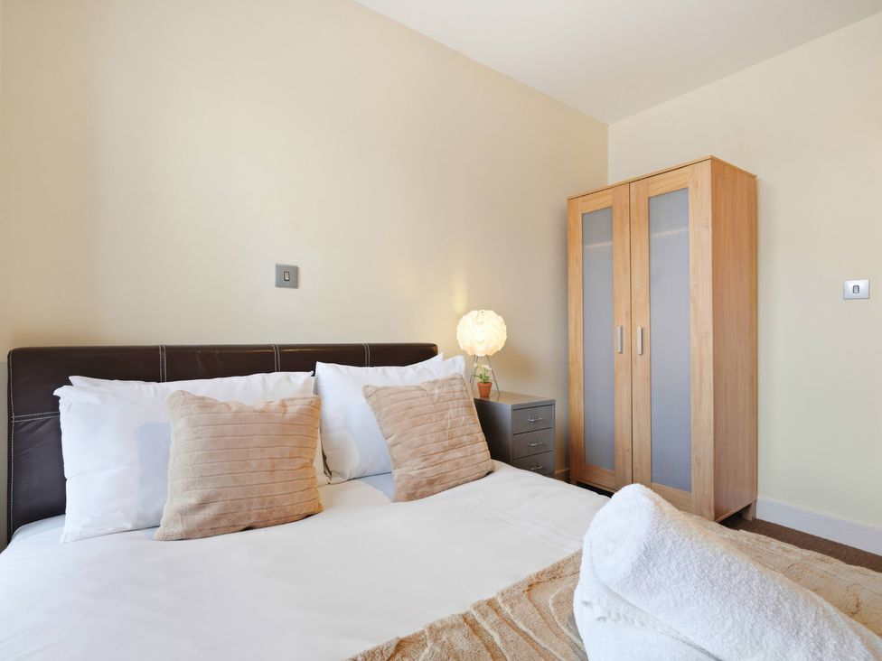 A bedroom with a bed and wardrobe at Apartment 28 in Birmingham