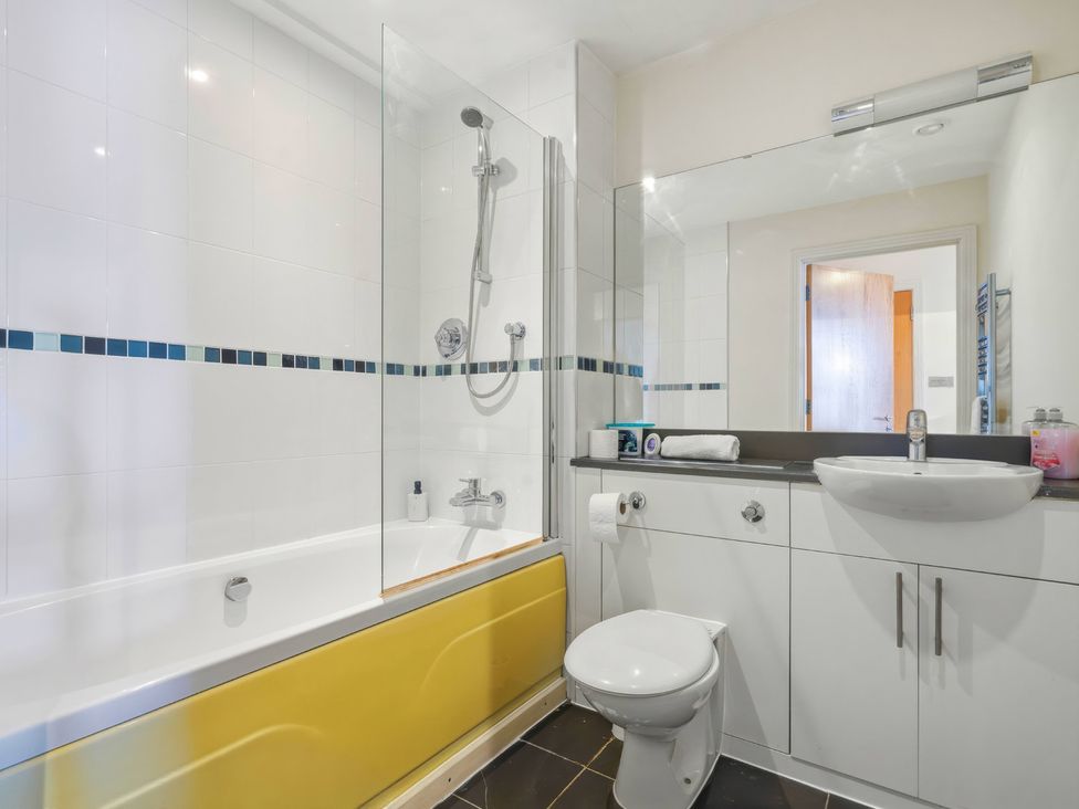 A bathroom with a bathtub, shower, toilet, and sink at Apartment 28 in Birmingham