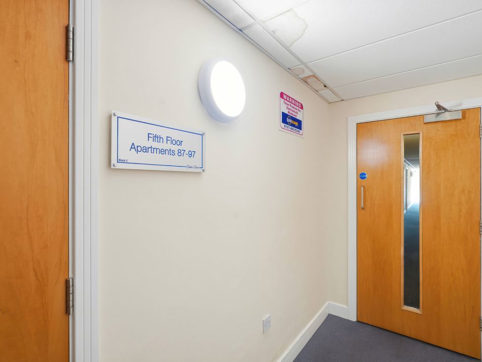 A corridor with a door and signage at Apartment 28 in Birmingham
