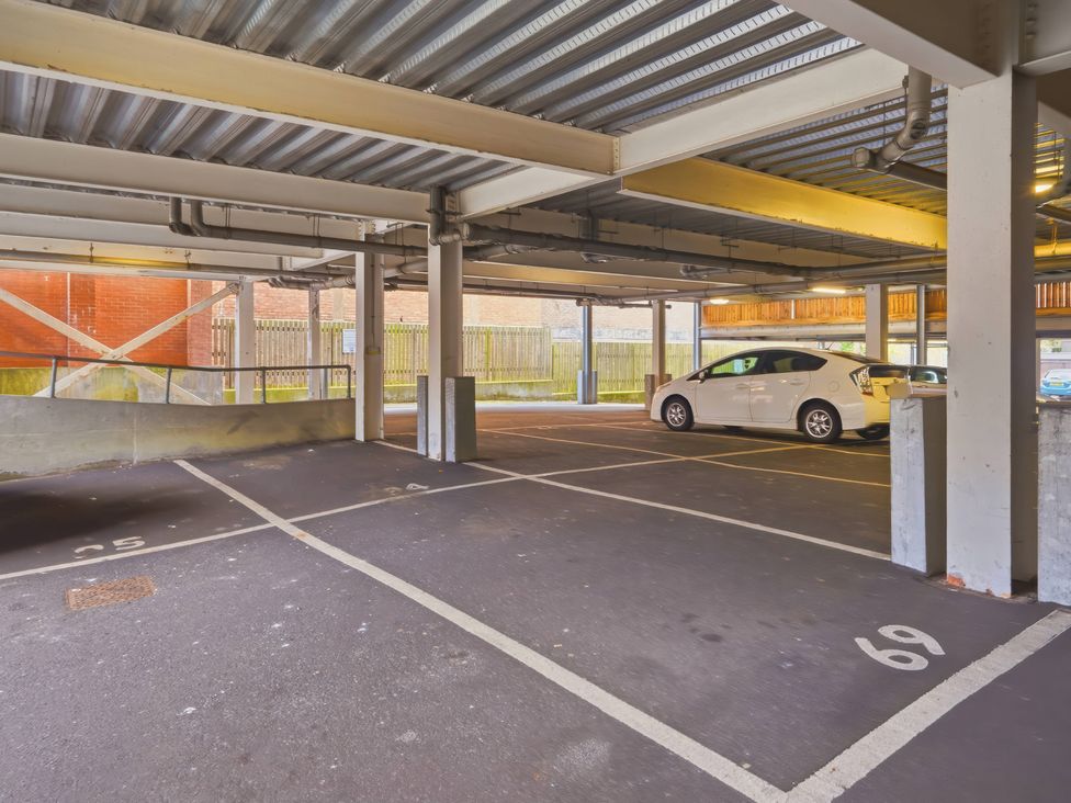 A parking garage with a white car parked at Apartment 28 in Birmingham