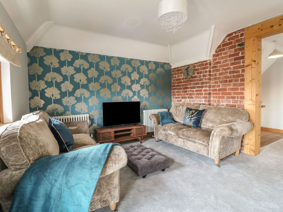 A living room with a television and sofas at Old Print House in Ilkeston