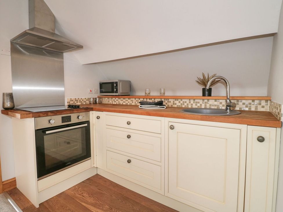 A kitchen with an oven, sink, and microwave at The Old Print House in Ilkeston