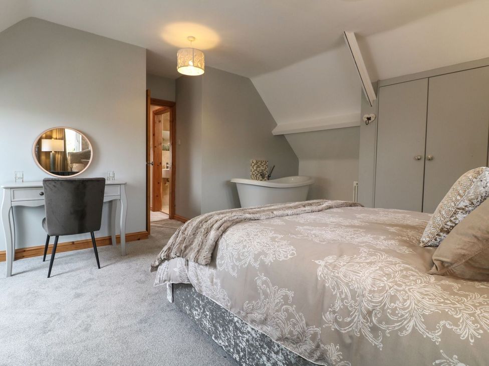 A bedroom with a bed and a vanity at the Old Print House in Ilkeston