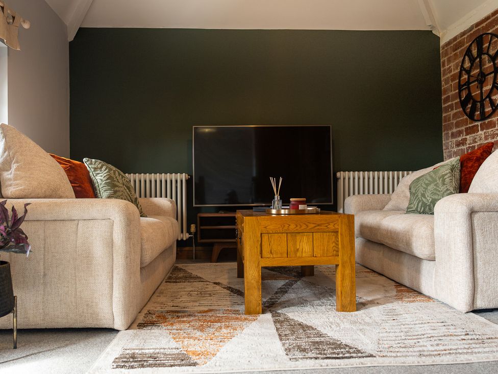A living room with a television and sofas at The Old Print House Stanley Common