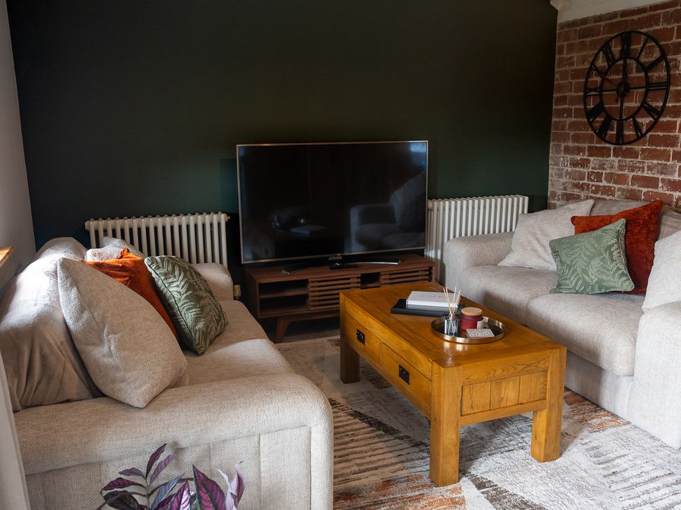 A living room with a television and sofa at The Old Print House in Stanley Common