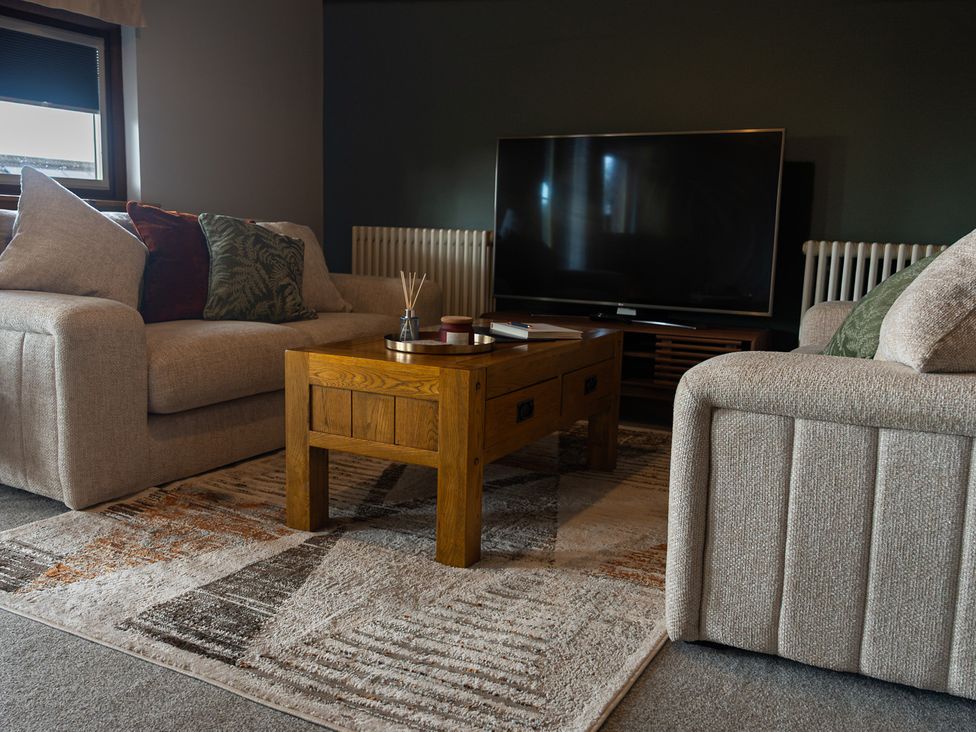 A living room with a sofa and a coffee table at The Old Print House in Stanley Common