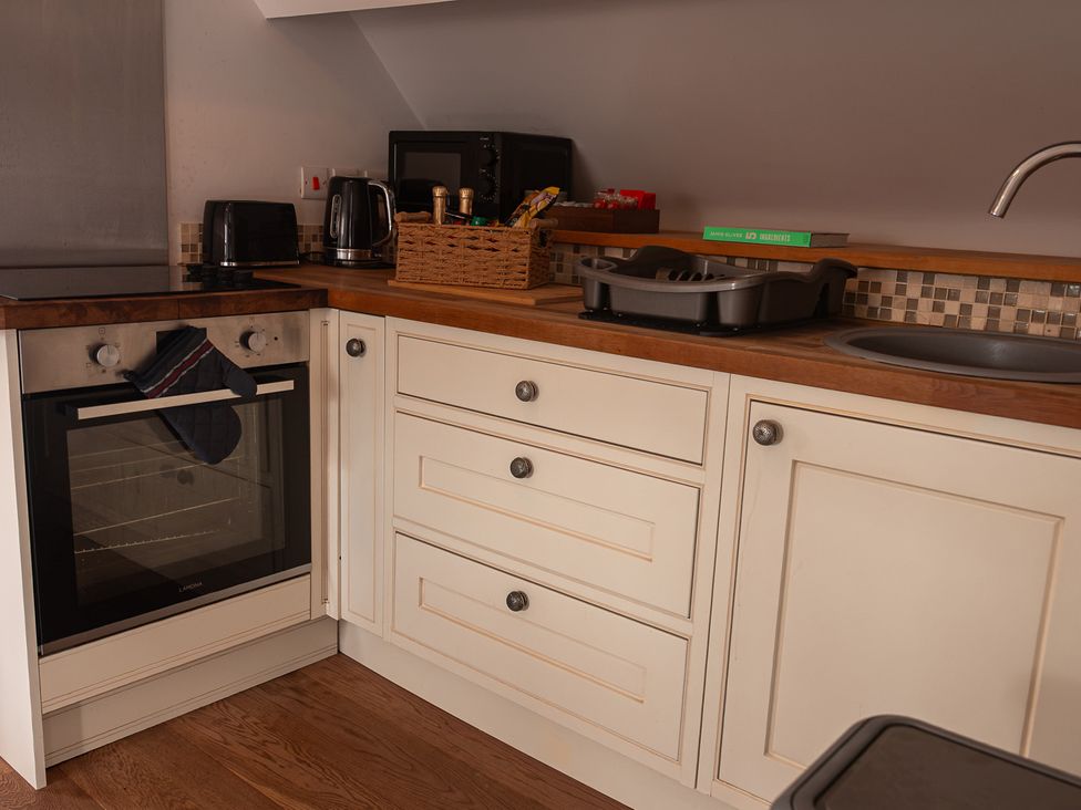 A kitchen with an oven, kettle, and microwave at The Old Print House in Stanley Common