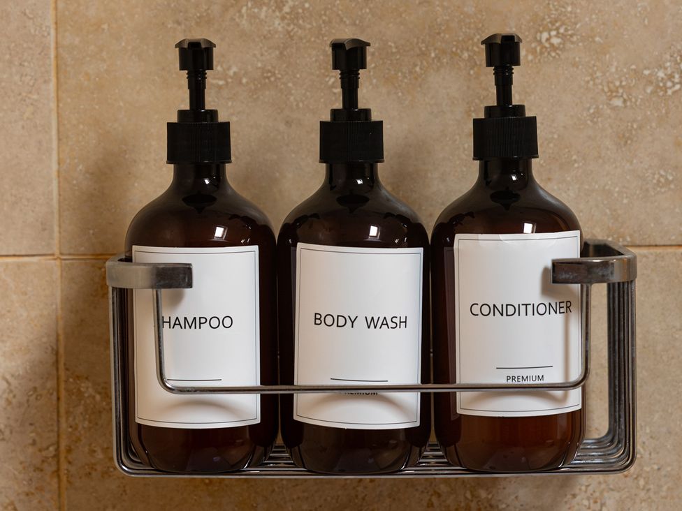 Three bottles labeled shampoo, body wash, and conditioner at The Old Print House in Stanley Common