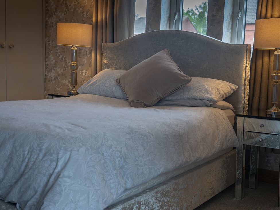 A bedroom with a bed and bedside lamp at The Old Print House in Stanley Common