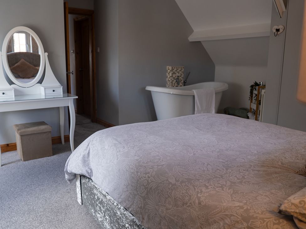 A bedroom with a bed and a bathtub at The Old Print House in Stanley Common