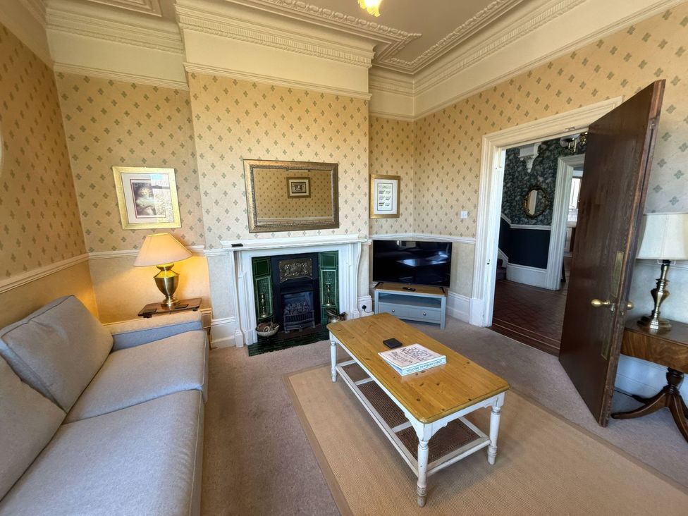 A living room with a sofa, table, and television at Ryburn Lodge in Bridlington