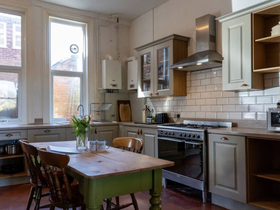 A kitchen with cabinets, stove, and dining table at Ryburn Lodge in Bridlington