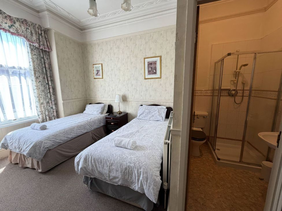 A bedroom with twin beds and an ensuite bathroom at Ryburn Lodge in Bridlington