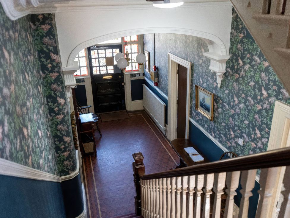 A hallway with a staircase and a front door at Ryburn Lodge in Bridlington