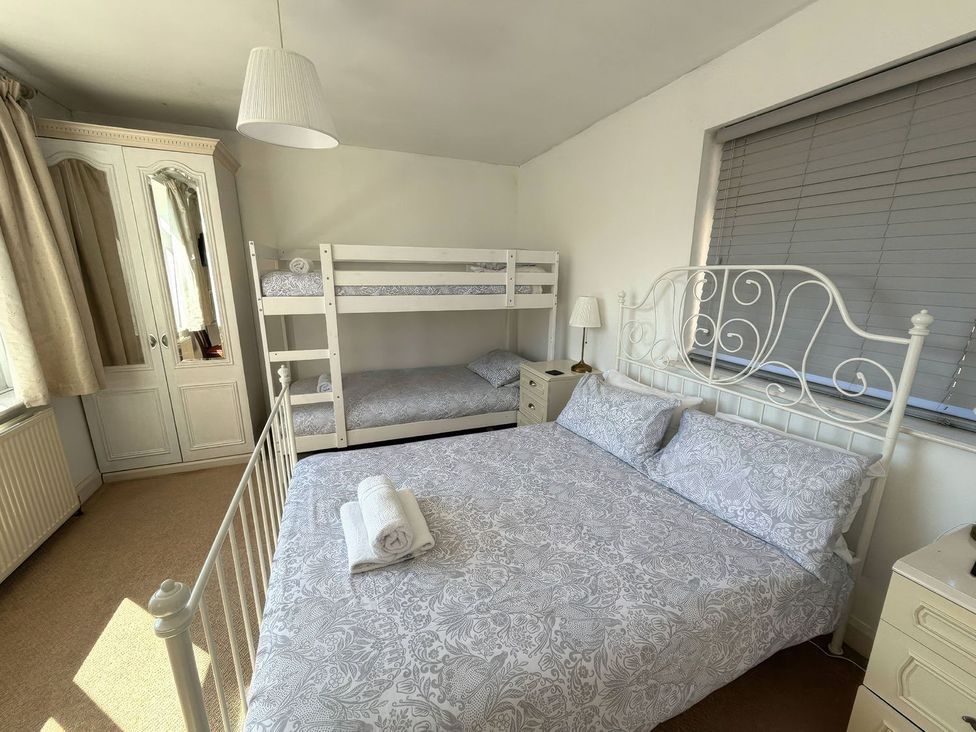 A bedroom with a double bed and bunk bed at Ryburn Lodge in Bridlington