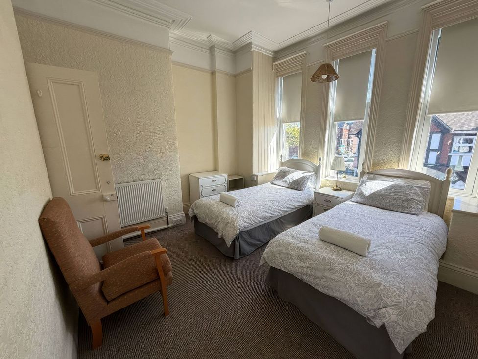 A bedroom with twin beds and a chair at Ryburn Lodge in Bridlington