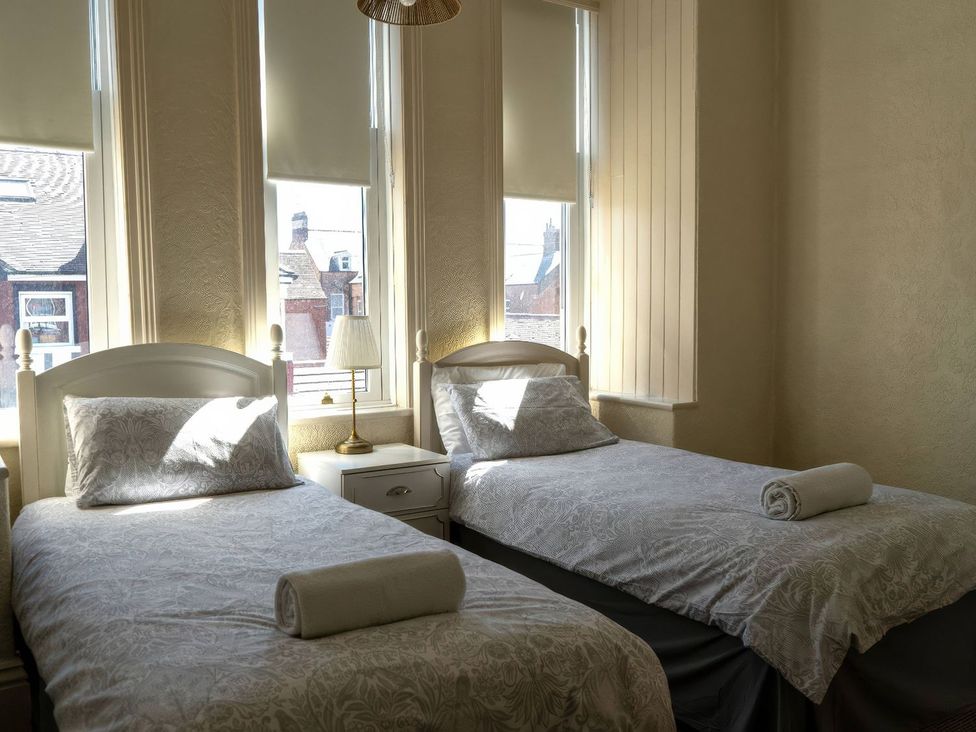 A bedroom with two beds and a bedside table at Ryburn Lodge in Bridlington