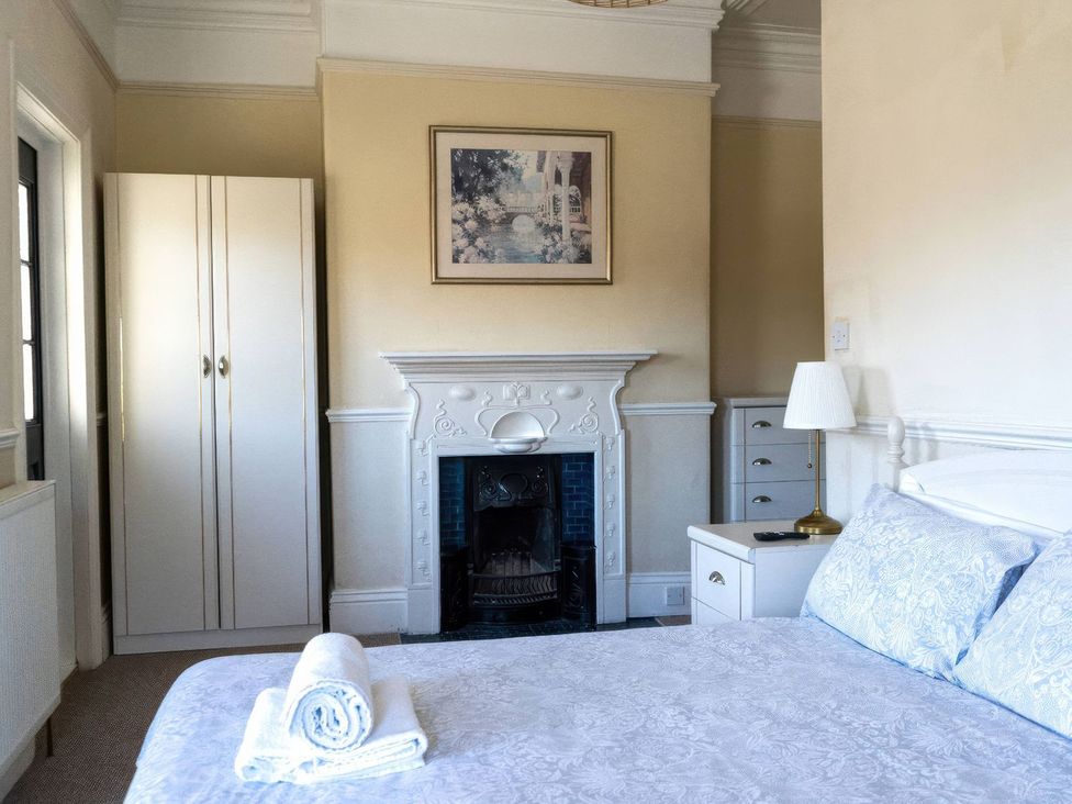 A bedroom with a bed, wardrobe, and fireplace at Ryburn Lodge in Bridlington