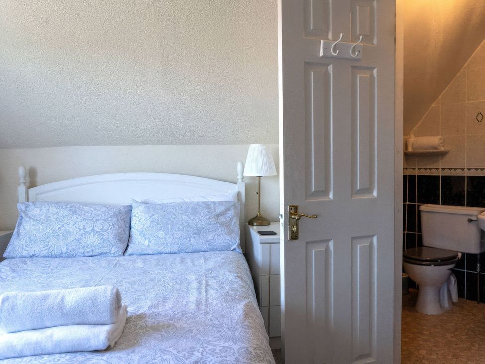 A bedroom with bed and adjoining bathroom at Ryburn Lodge in Bridlington