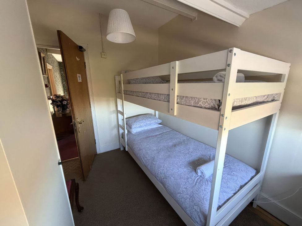 A bedroom with a bunk bed and a single bed at Ryburn Lodge Bridlington