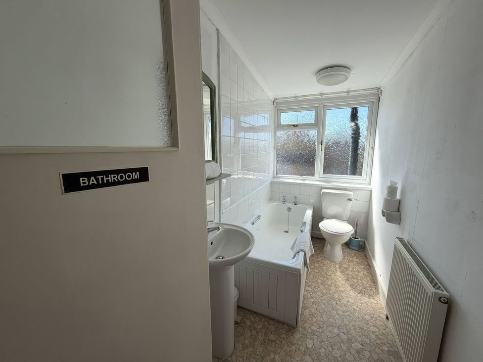 A bathroom with a sink, toilet, and bath tub at Ryburn Lodge in Bridlington