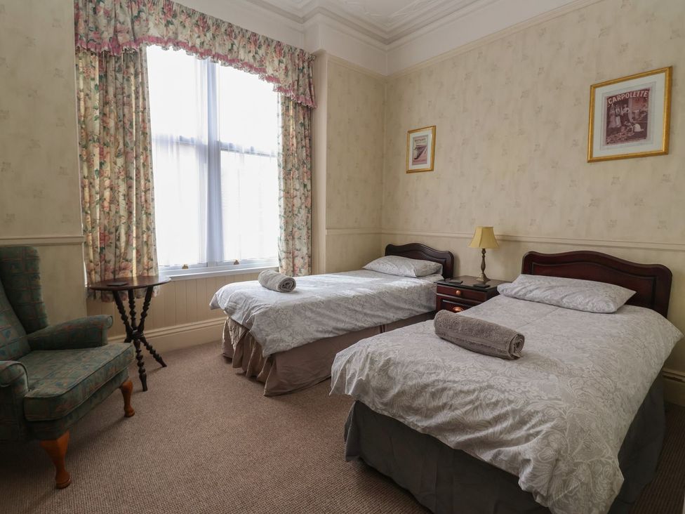 A bedroom with two single beds and a chair at Ryburn Lodge in Bridlington