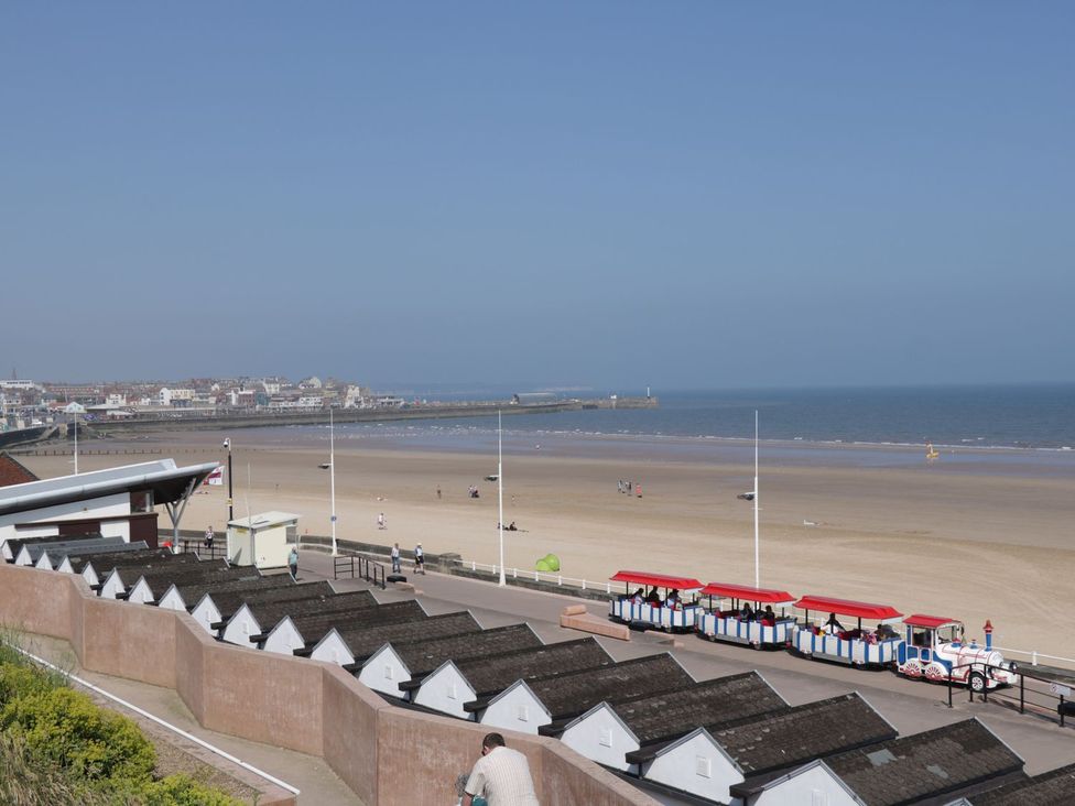 A beach with huts and people at Ryburn Lodge in Bridlington