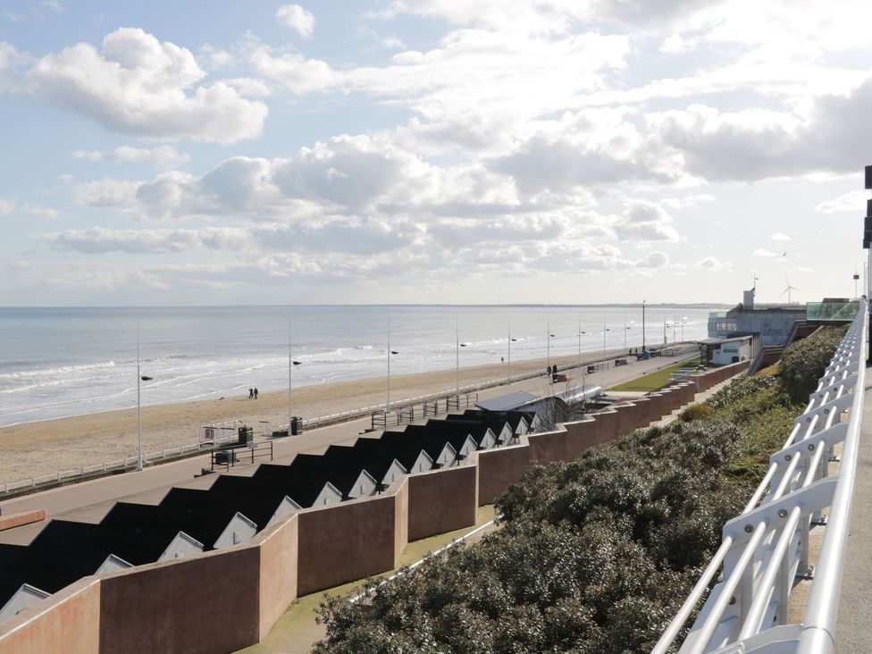 A beach view with beach huts and a path at Ryburn Lodge in Bridlington