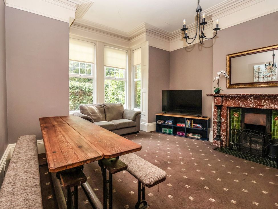 A living room with a table, sofa, and TV at Trinity Lodge in Bridlington