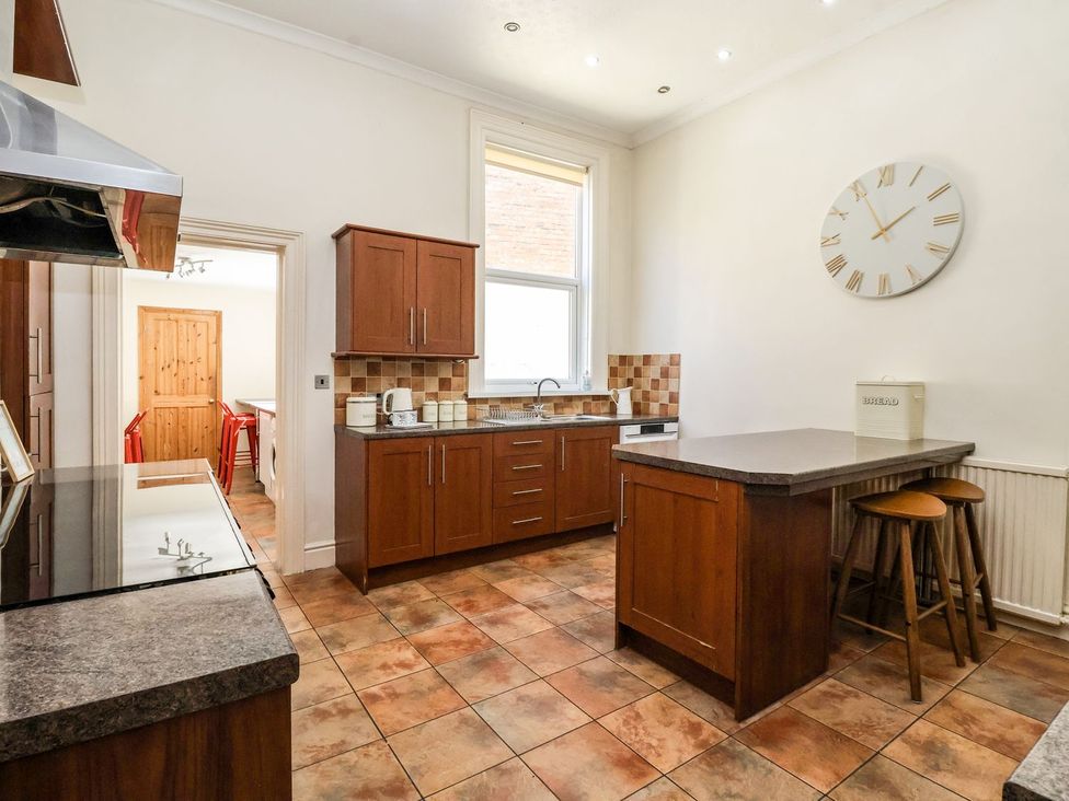A kitchen with wooden cabinets and a sink at Trinity Lodge in Bridlington