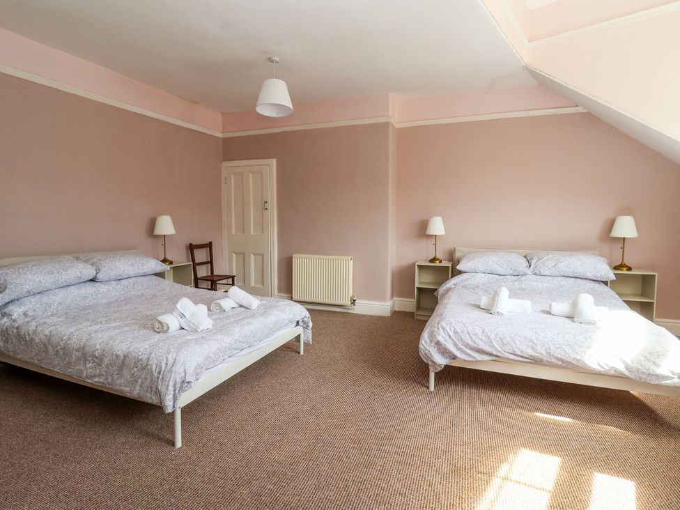 A bedroom with two beds and a chair at Trinity Lodge in Bridlington