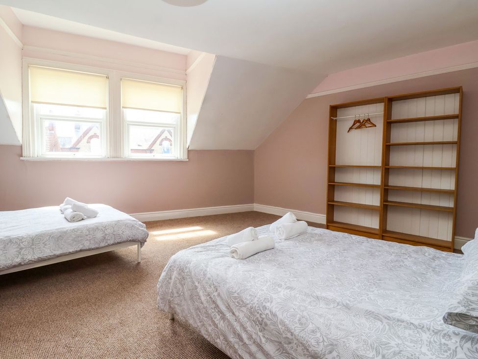 A bedroom with two beds and a shelf at Trinity Lodge in Bridlington