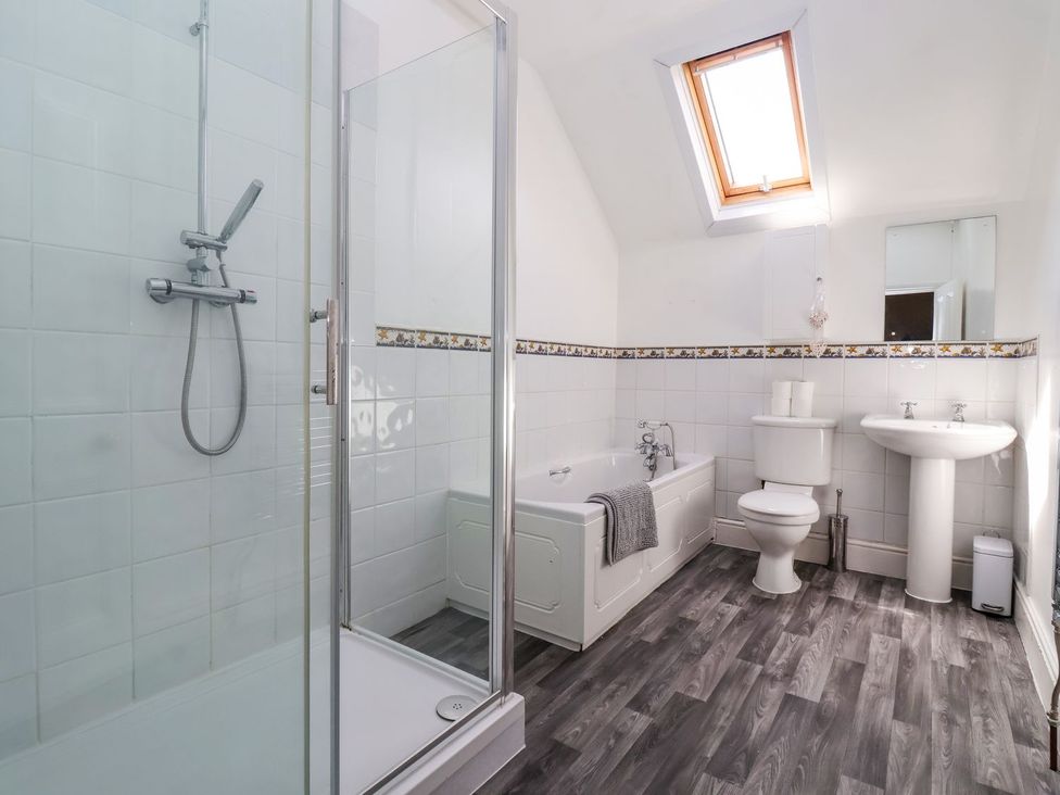 A bathroom with shower, bathtub, toilet, and sink at Trinity Lodge in Bridlington