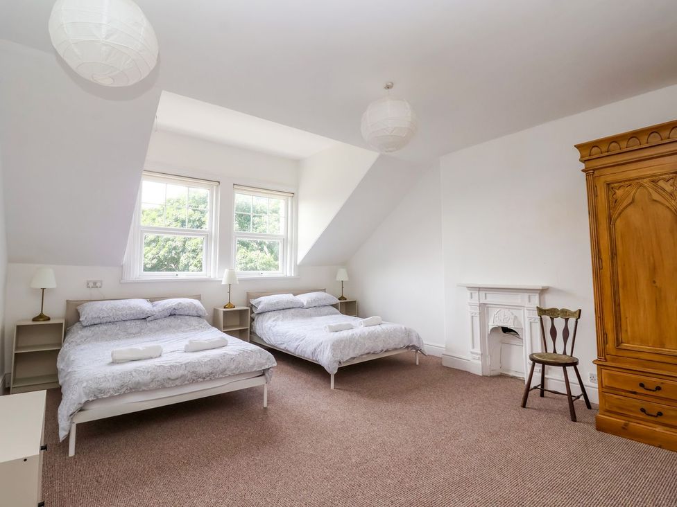 A bedroom with two beds and a wardrobe at Trinity Lodge in Bridlington