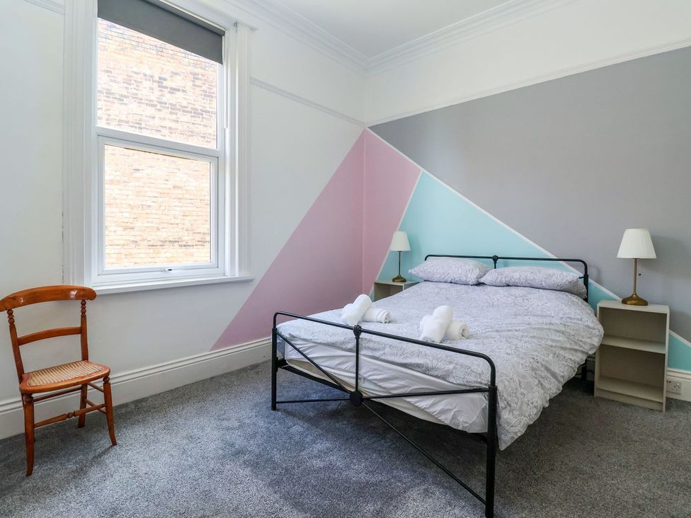 A bedroom with a bed and chair at Trinity Lodge in Bridlington