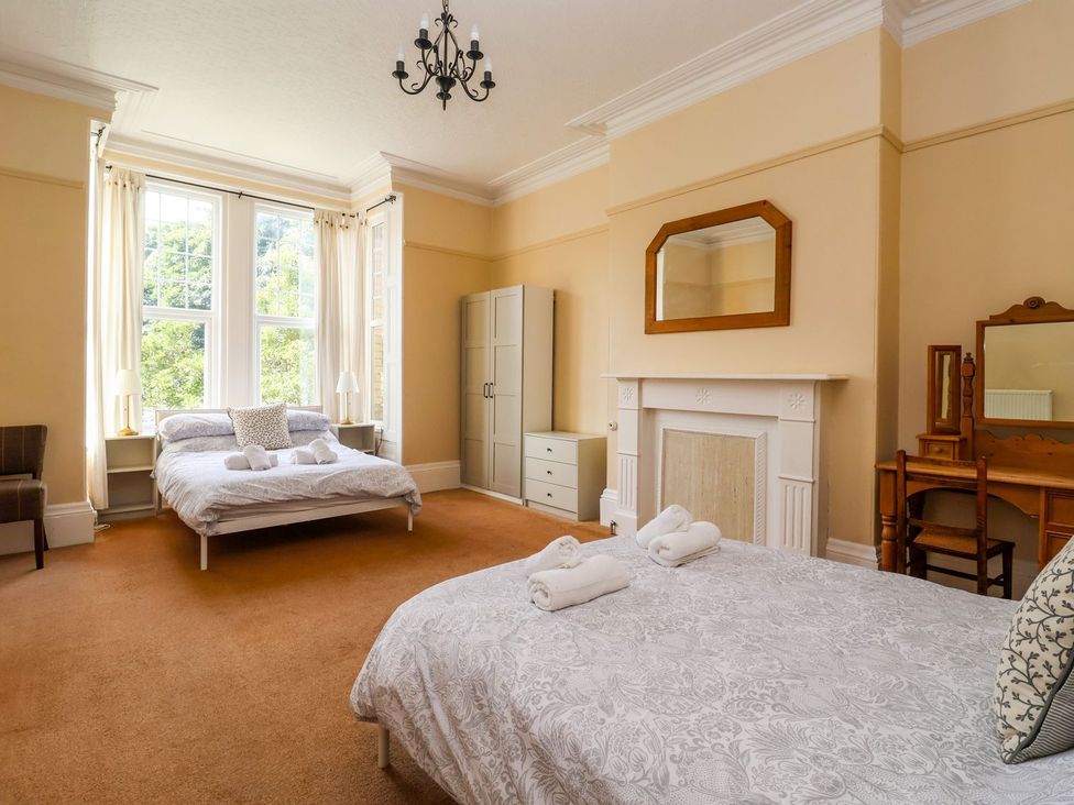 A bedroom with two beds and a dresser at Trinity Lodge in Bridlington