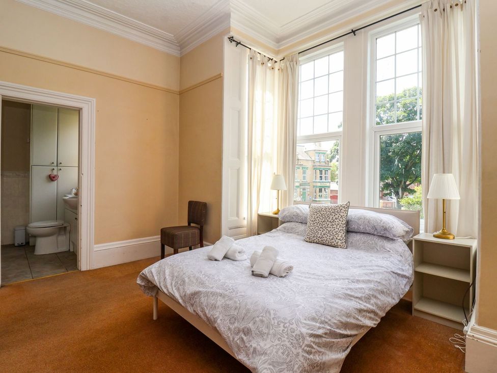 A bedroom with a bed and a bathroom at Trinity Lodge in Bridlington
