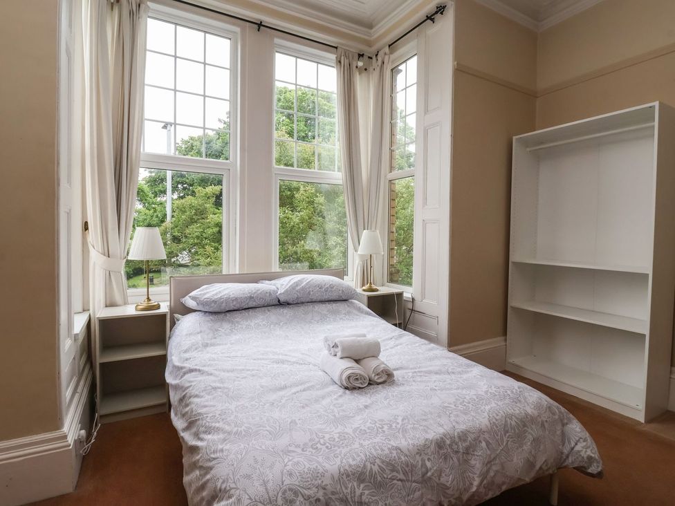 A bedroom with a bed and shelves at Trinity Lodge in Bridlington