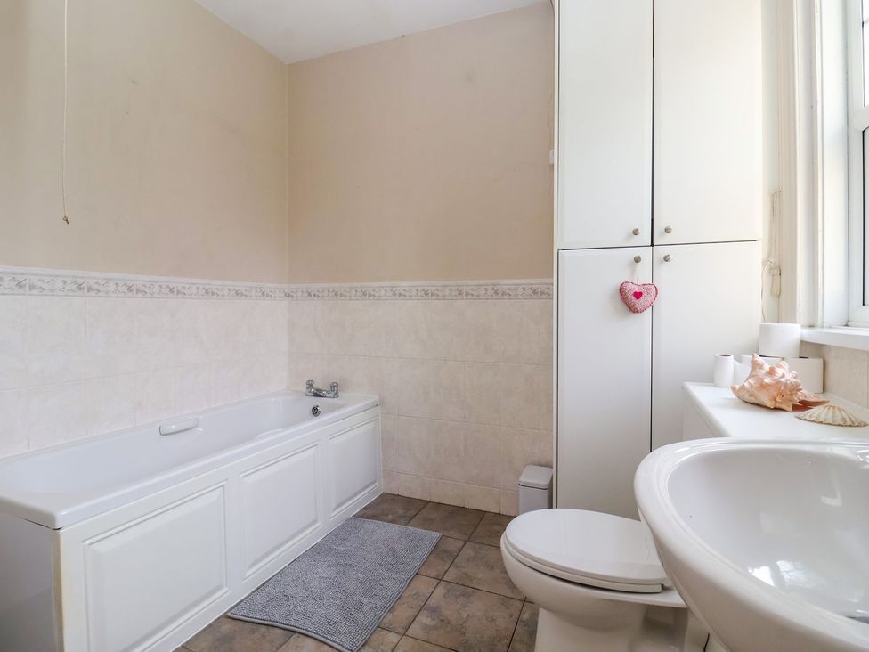 A bathroom with a bathtub, toilet and sink at Trinity Lodge, Bridlington