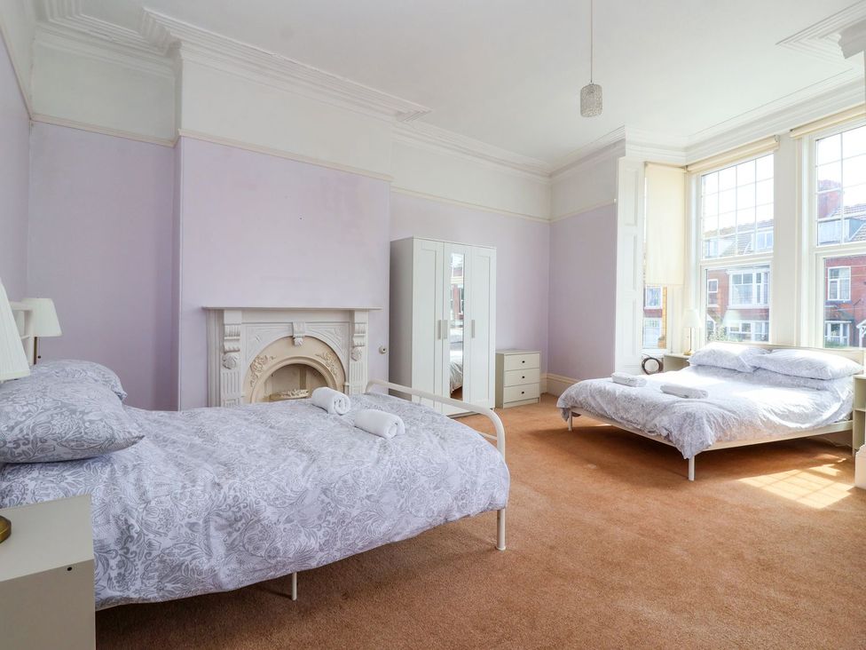 A bedroom with two beds and a dresser at Trinity Lodge in Bridlington