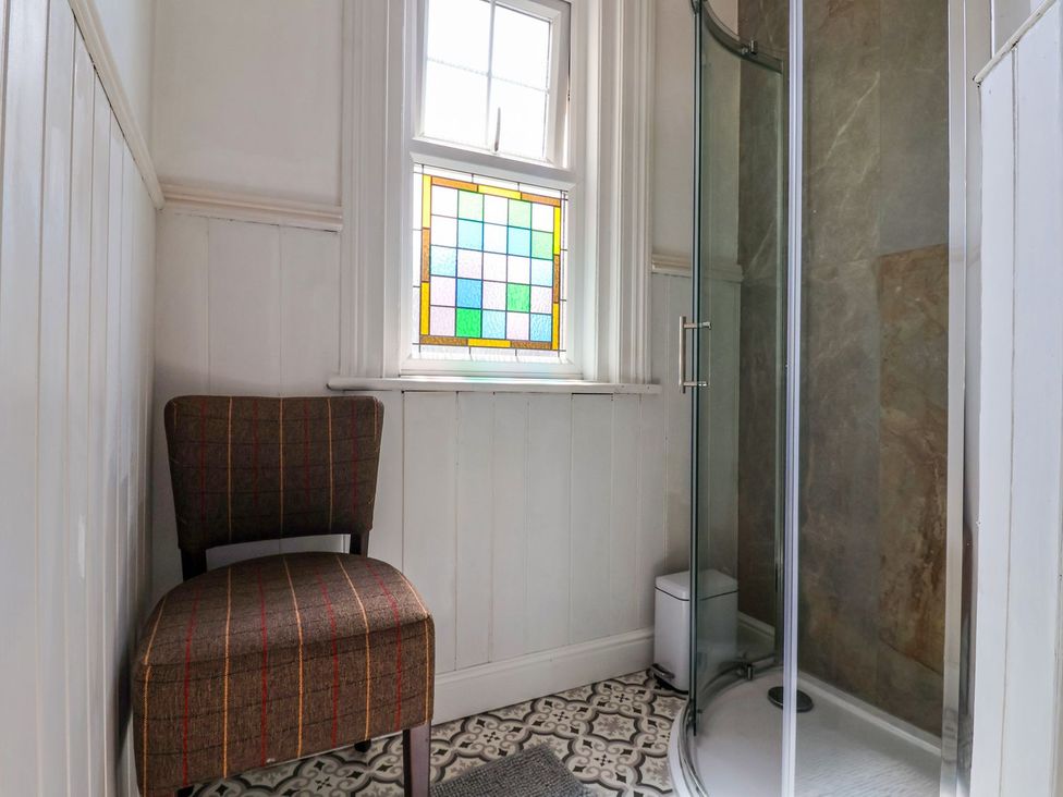 A bathroom with a chair and shower at Trinity Lodge in Bridlington