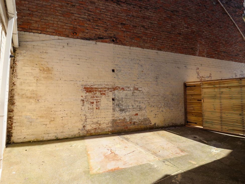 An outdoor area with brick wall and wooden fence at Trinity Lodge in Bridlington