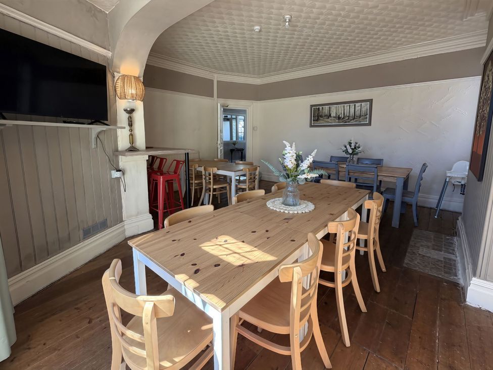 A dining room with a long table and chairs at Avalon Lodge in Bridlington
