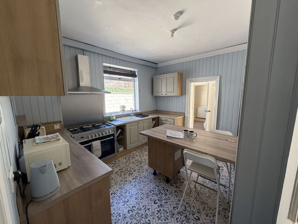 A kitchen with cabinets and a table at Avalon Lodge in Bridlington