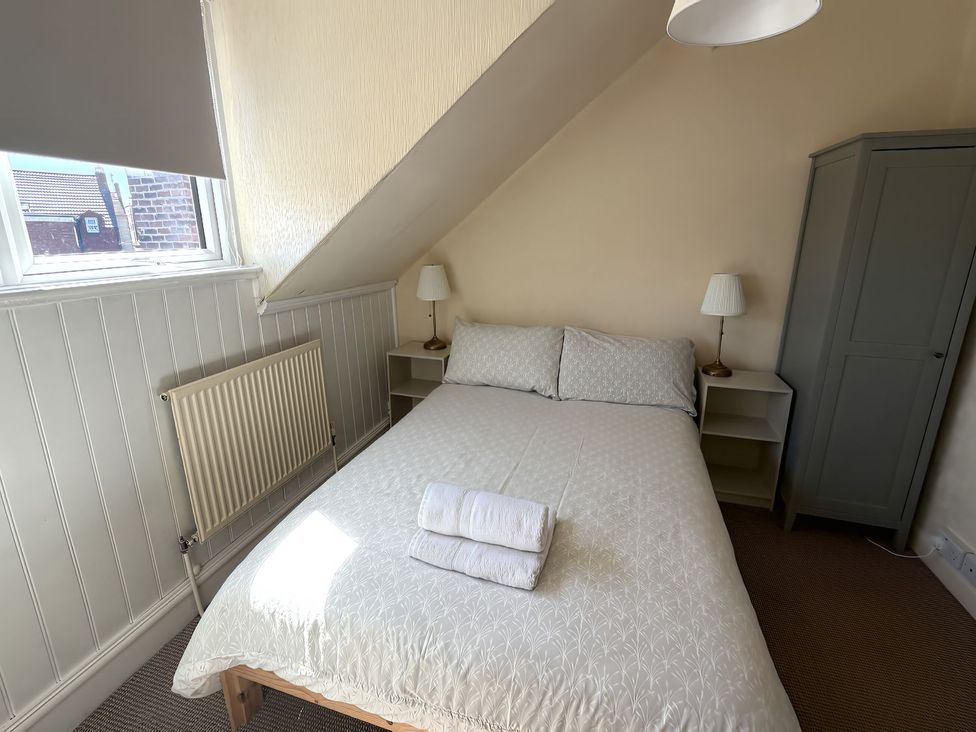 A bedroom with a bed, bedside tables and a wardrobe at Avalon Lodge in Bridlington