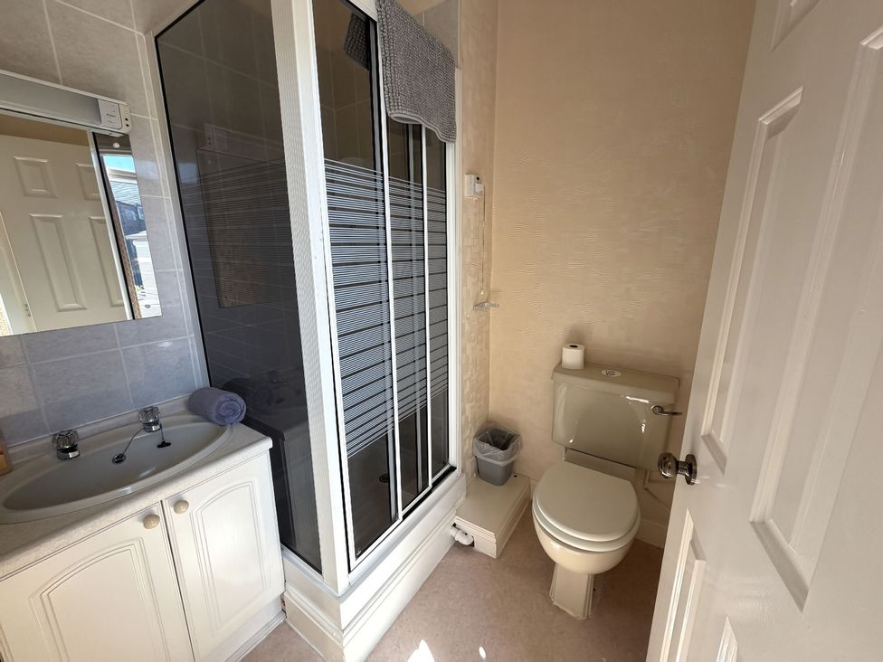 A bathroom with a shower, toilet, and sink at Avalon Lodge in Bridlington