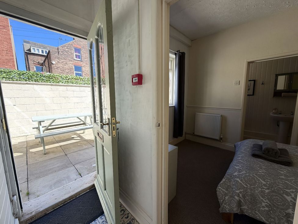 A bedroom with an open door leading to a garden at Avalon Lodge in Bridlington