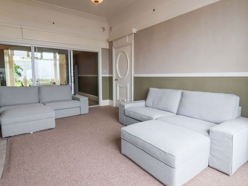 A living room with sofas and sliding door at Sunrise Lodge in Bridlington